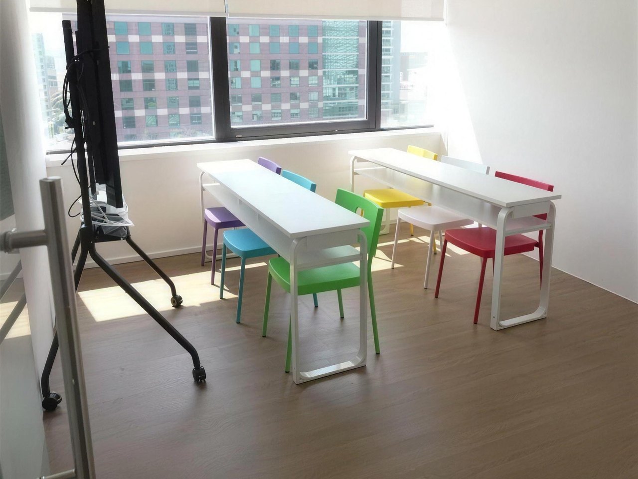 Bright Tian Yun classroom with long study desks, colourful chairs and a city view